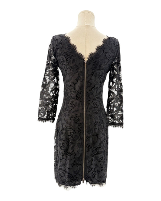 Black lace dress on a mannequin against a white background