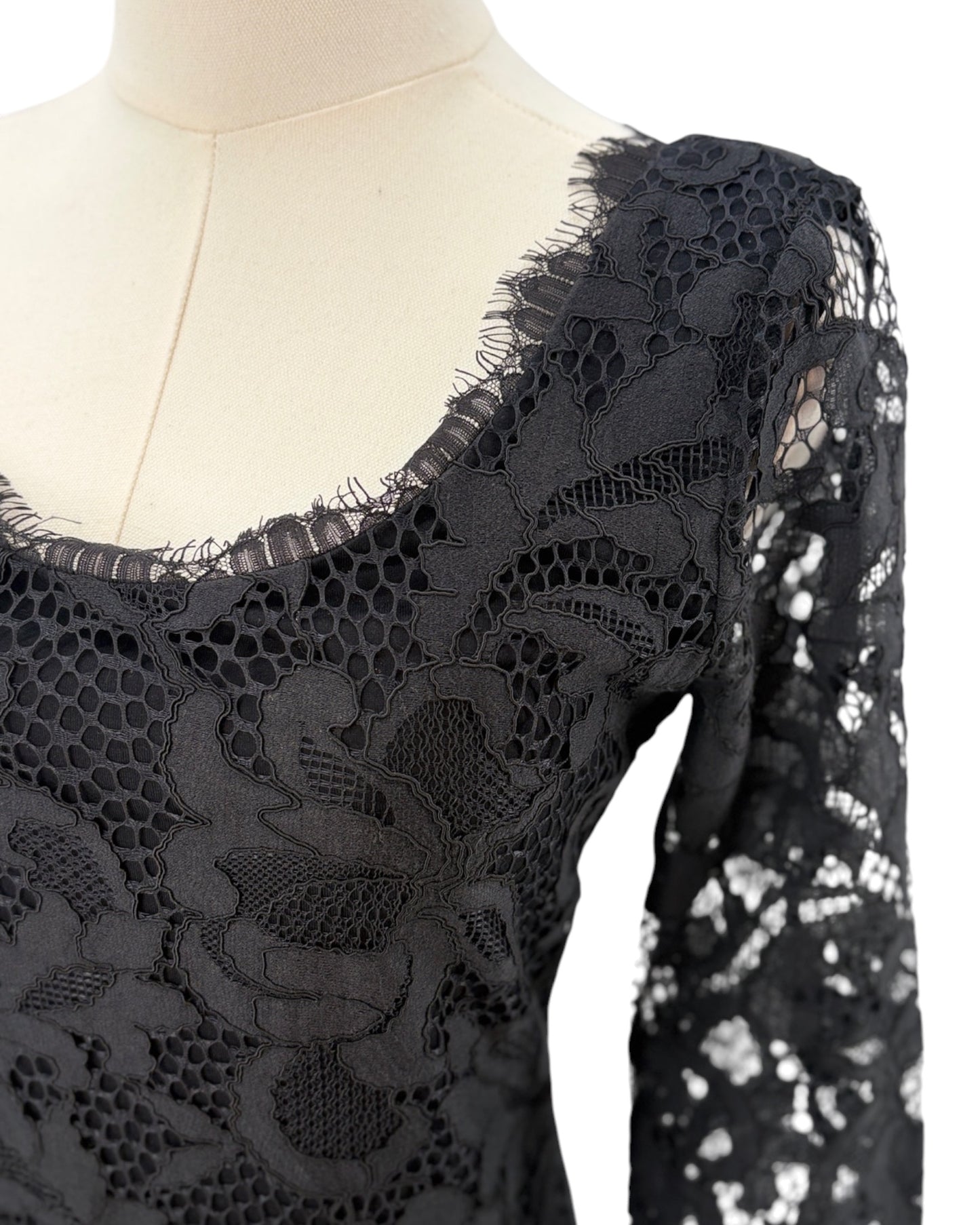 Black lace dress on a mannequin with a white background