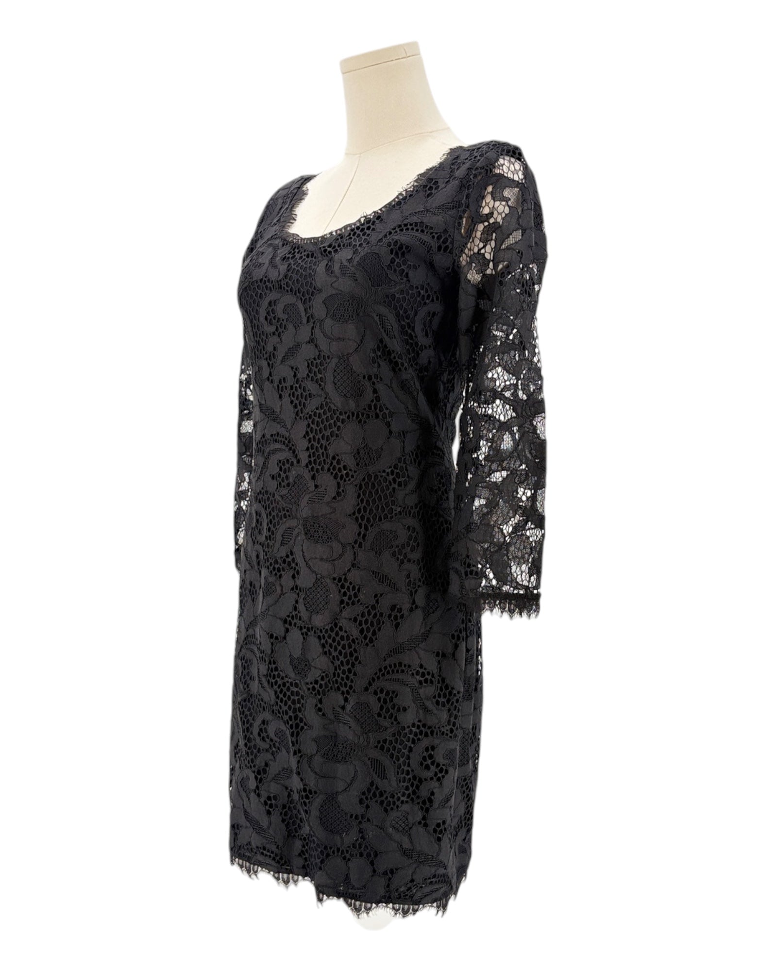 Black lace dress on a mannequin against a white background