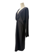 Black draped dress on a mannequin against a white background
