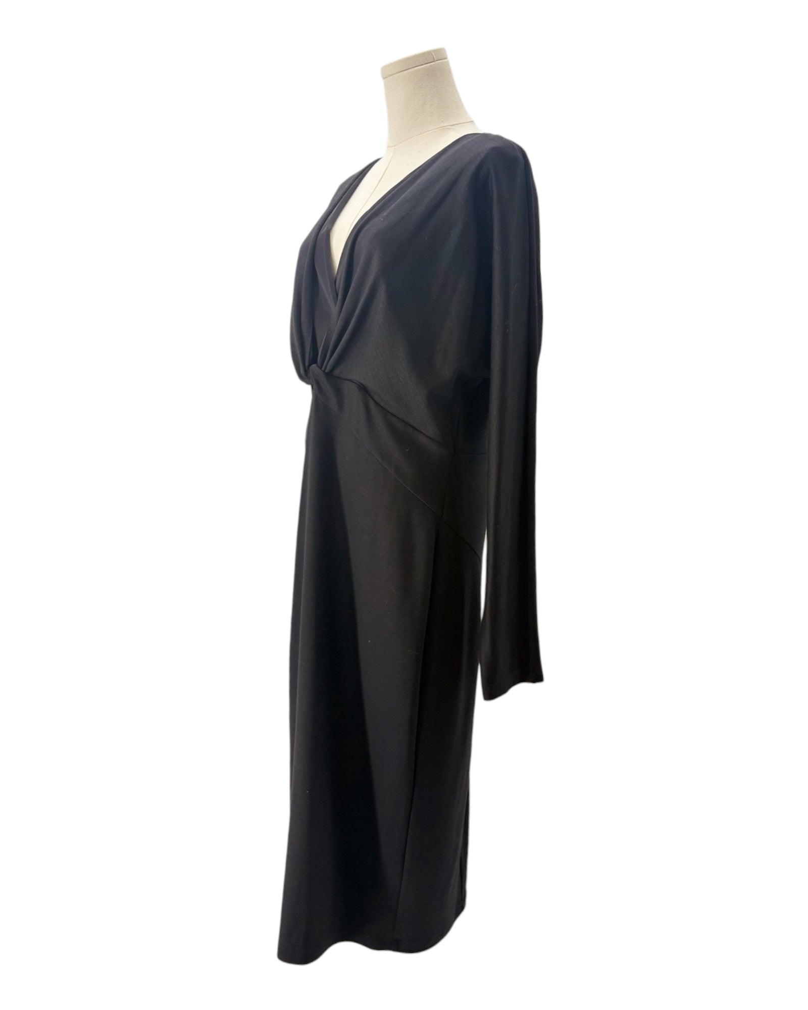 Black draped dress on a mannequin against a white background