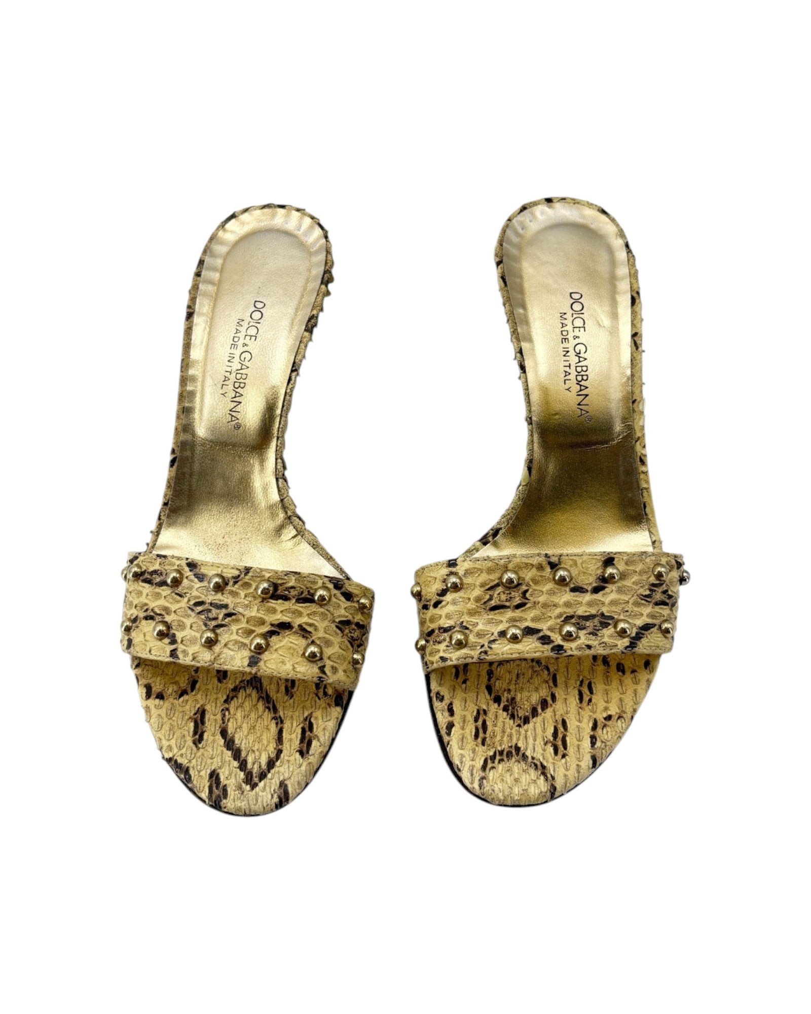 Gold high-heeled shoes with snake print pattern on a white background