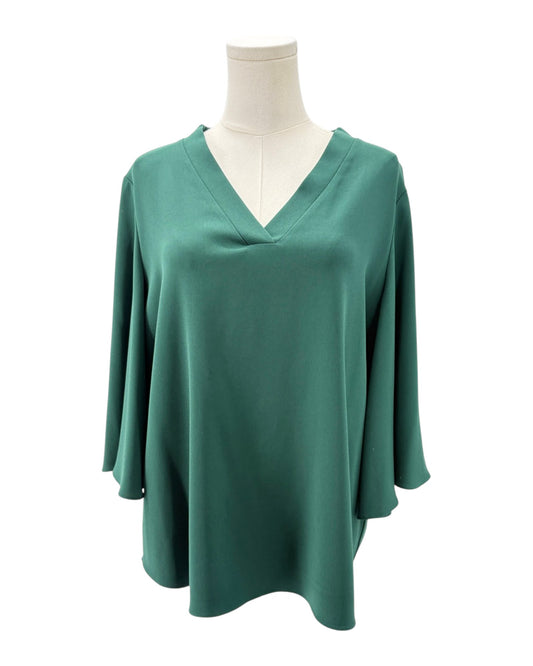 Green blouse on a mannequin against a white background