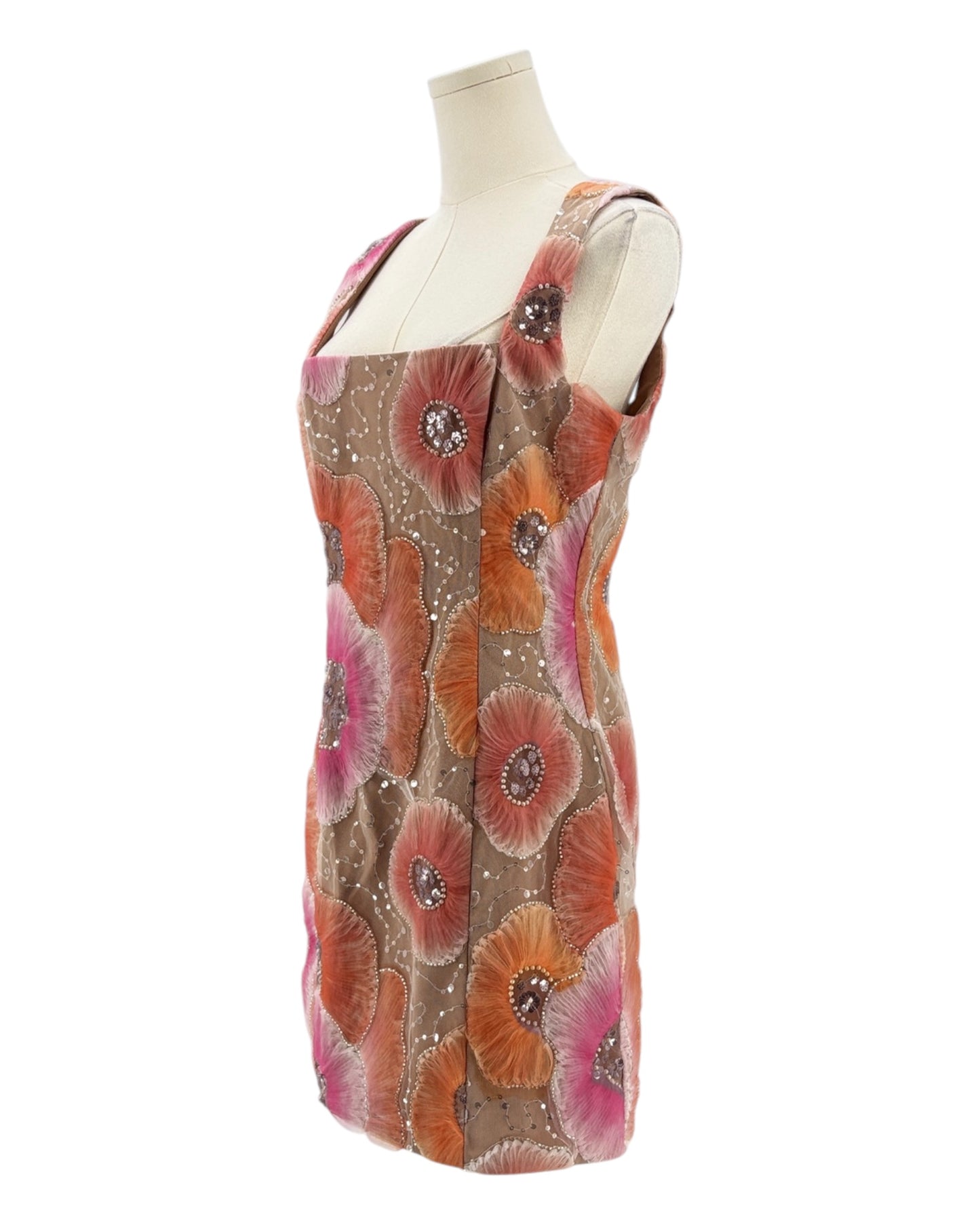 Mannequin wearing a floral dress with orange and pink flowers on a white background