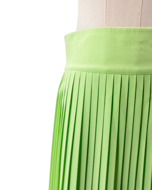 Green pleated skirt on a mannequin against a white background