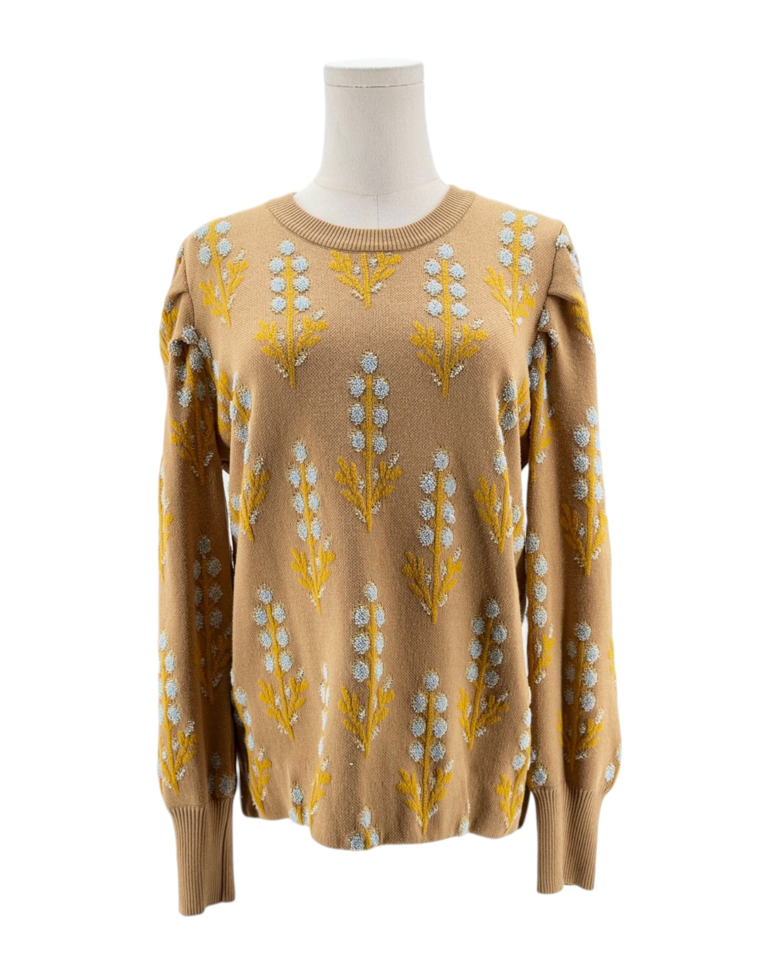 Beige sweater with floral pattern on a mannequin against a white background