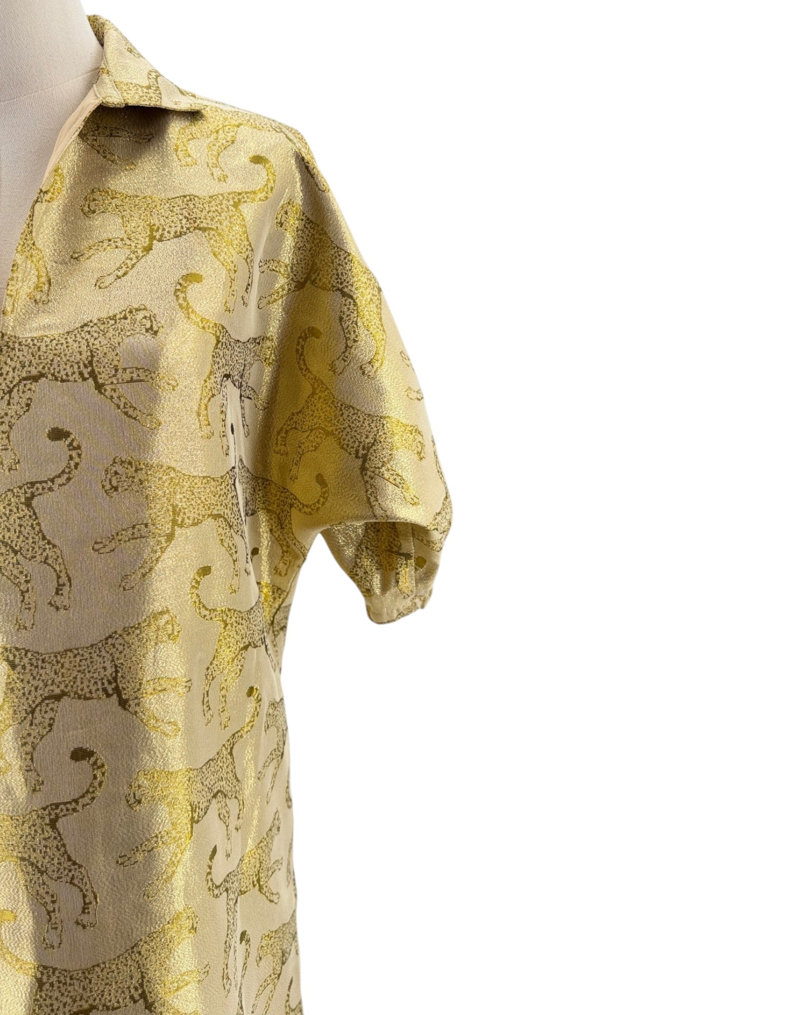 Mannequin wearing a gold and animal patterned shirt on a white background
