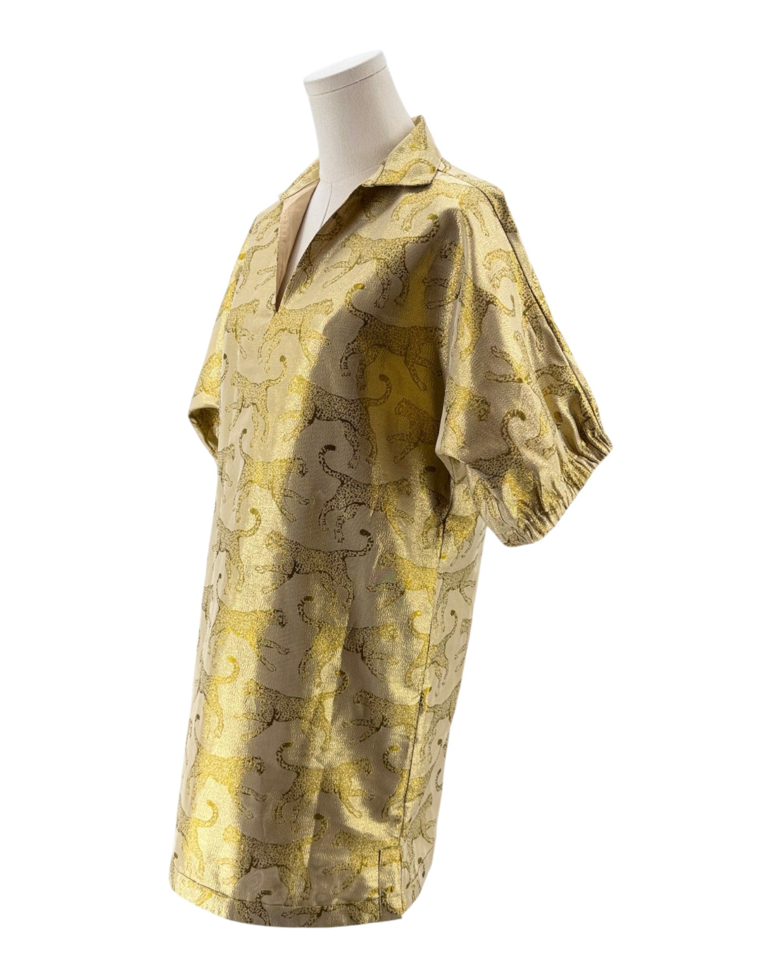 Gold patterned shirt on a mannequin against a white background
