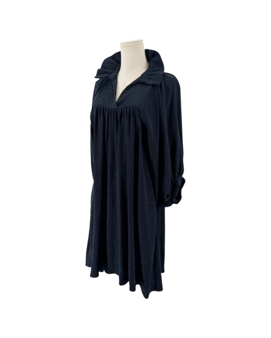 High ruffle stand-up collar, notched v-neck, gathered detailing at the bodice, voluminous loose blouson sleeves, shift silhouette, side pockets on a mannequin on a white background