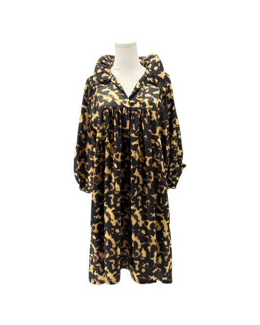 A long-sleeved hooded dress with a black and tan camouflage pattern, displayed on a white mannequin torso against a plain white background.