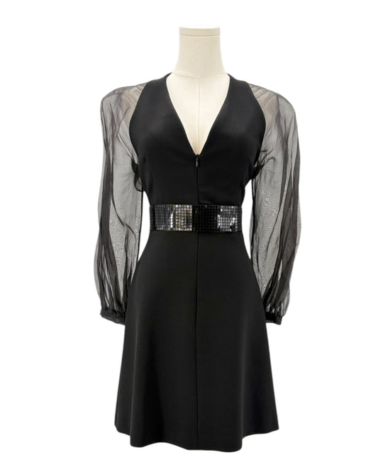 Black dress with sheer sleeves on a mannequin against a white background