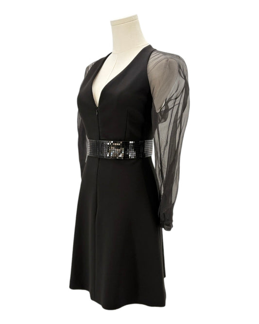 Black dress with sheer sleeves and sequined belt on a mannequin against a white background
