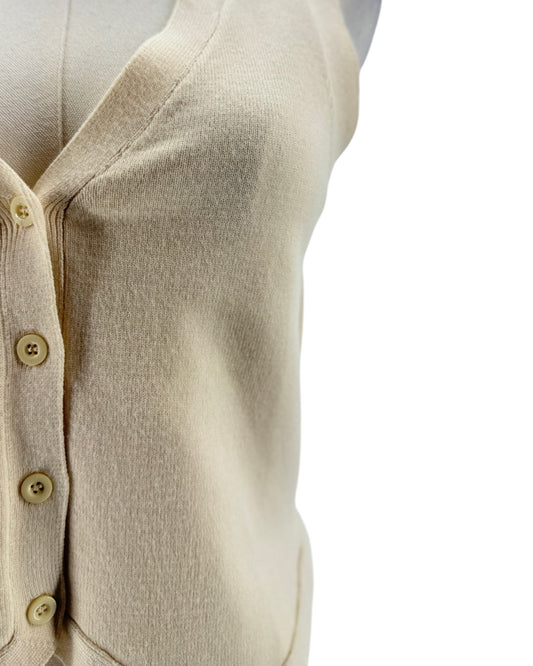 Close-up of a beige cardigan with button details on a white background