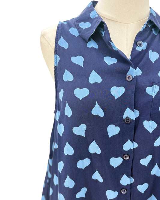 Navy sleeveless button down shirt with blue heart pattern on a mannequin against a white background