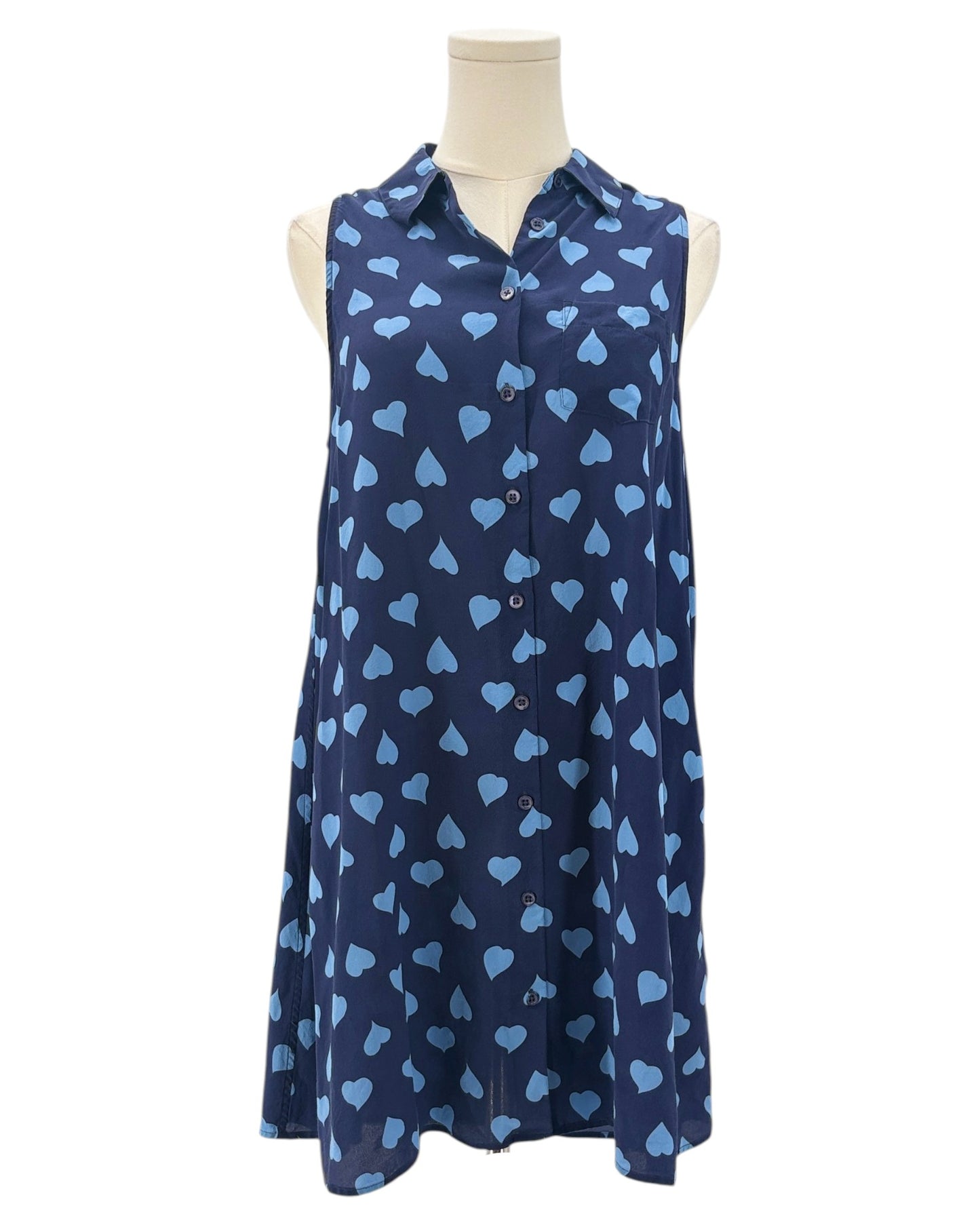 Navy sleeveless button down shirt with blue heart pattern on a mannequin against a white background