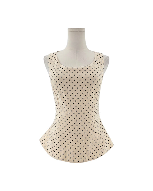 Sleeveless cream peplum top with back polka dots on a mannequin on a white background