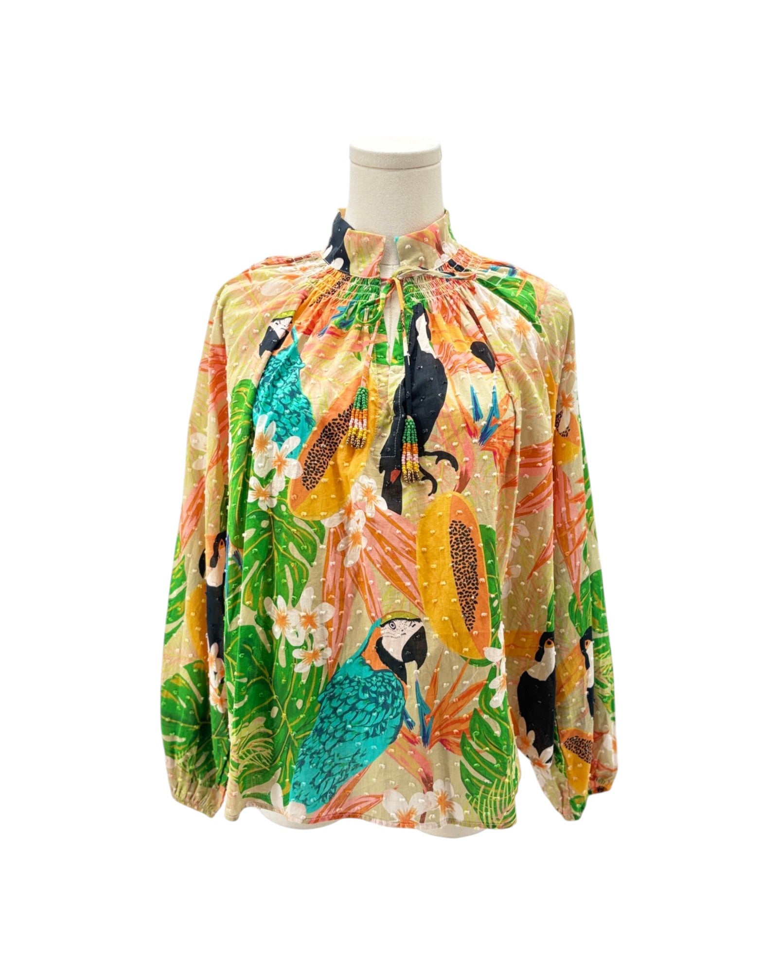 Colorful tropical-themed blouse on a mannequin against a white background
