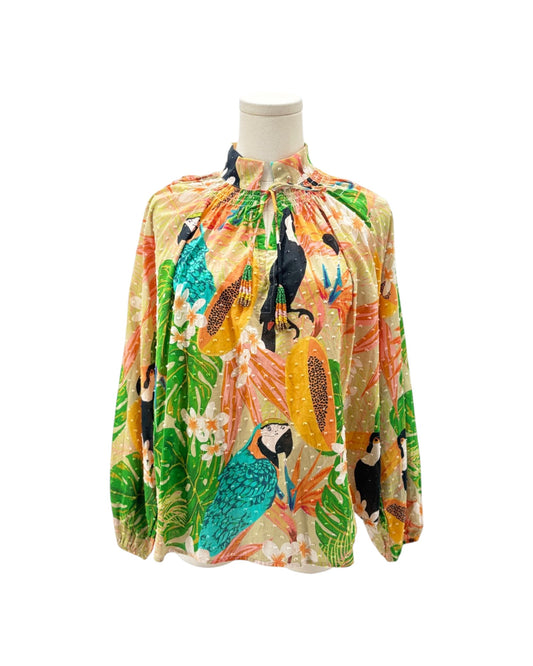 Colorful tropical-themed blouse on a mannequin against a white background
