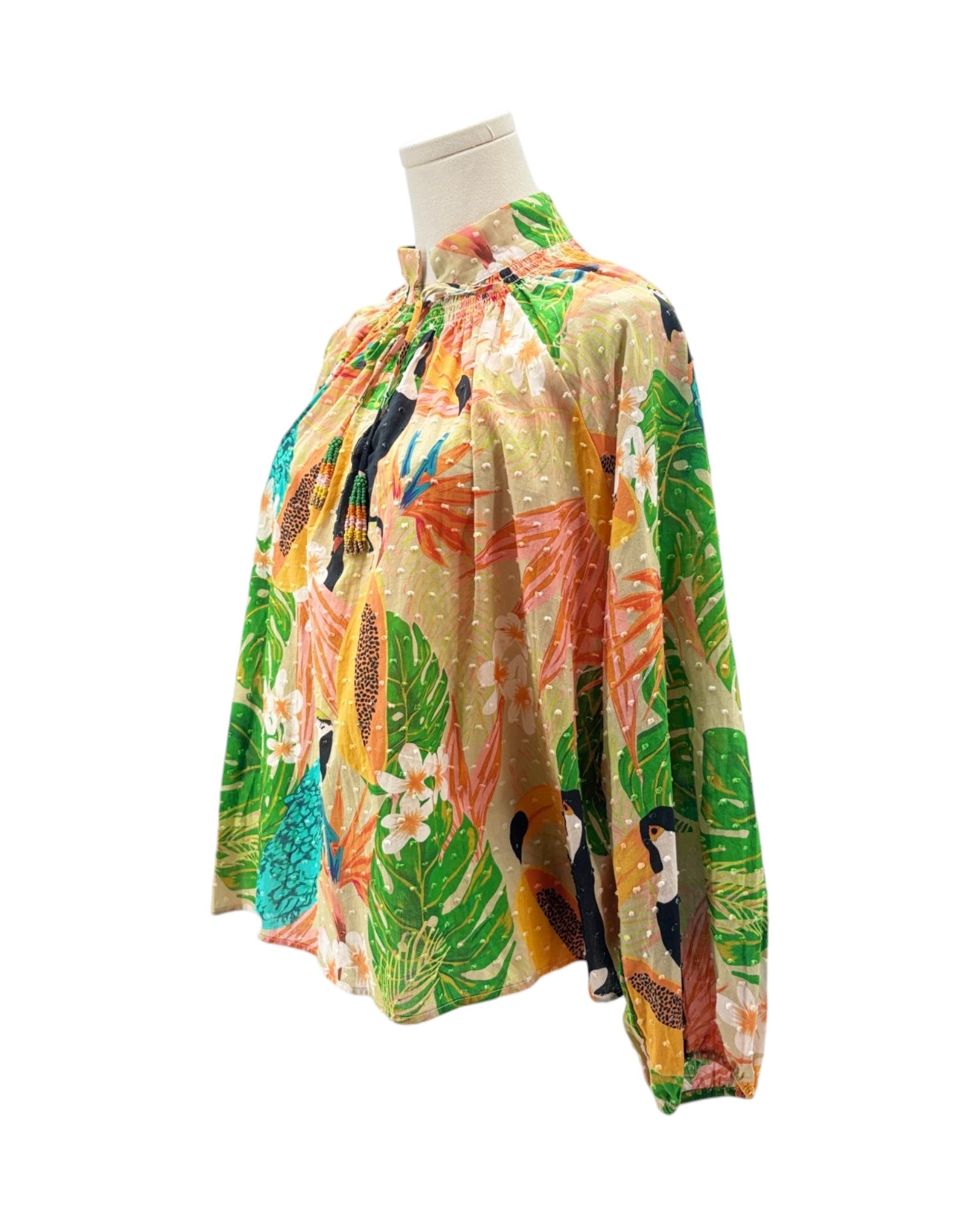 Colorful tropical print top on a mannequin against a white background