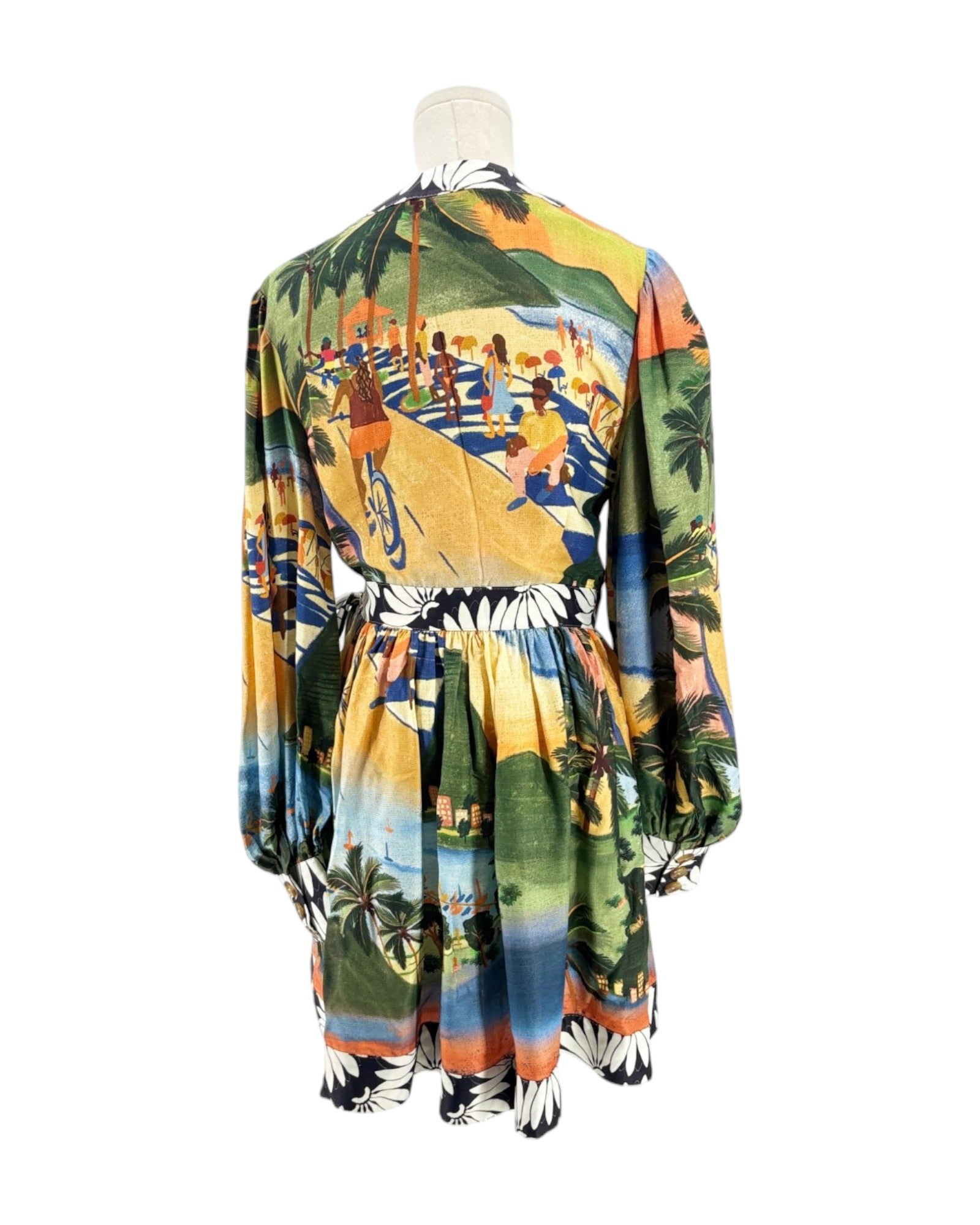 Colorful dress with a tropical beach scene print on a mannequin against a white background