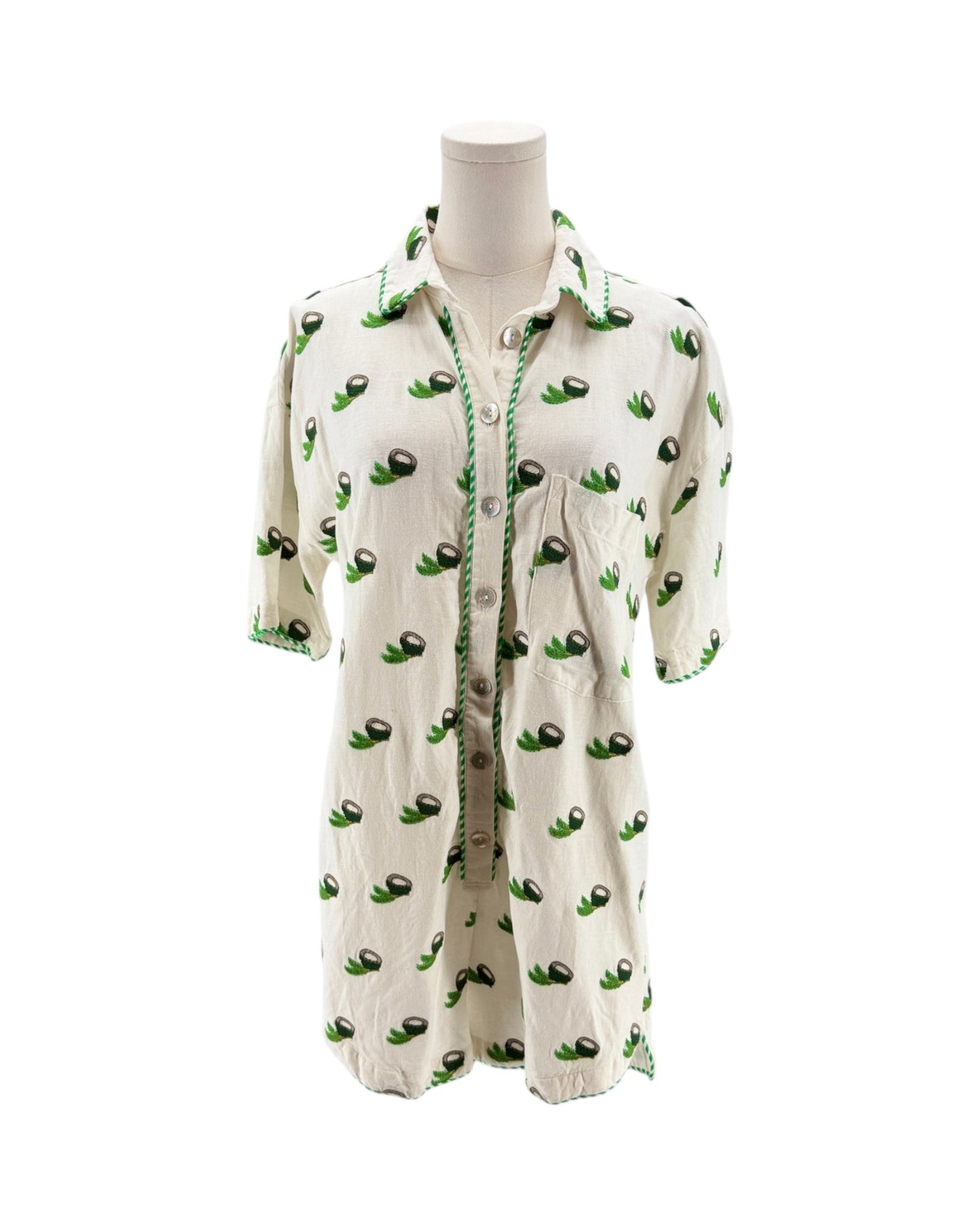 White shirt with green avocado pattern on a mannequin against a white background