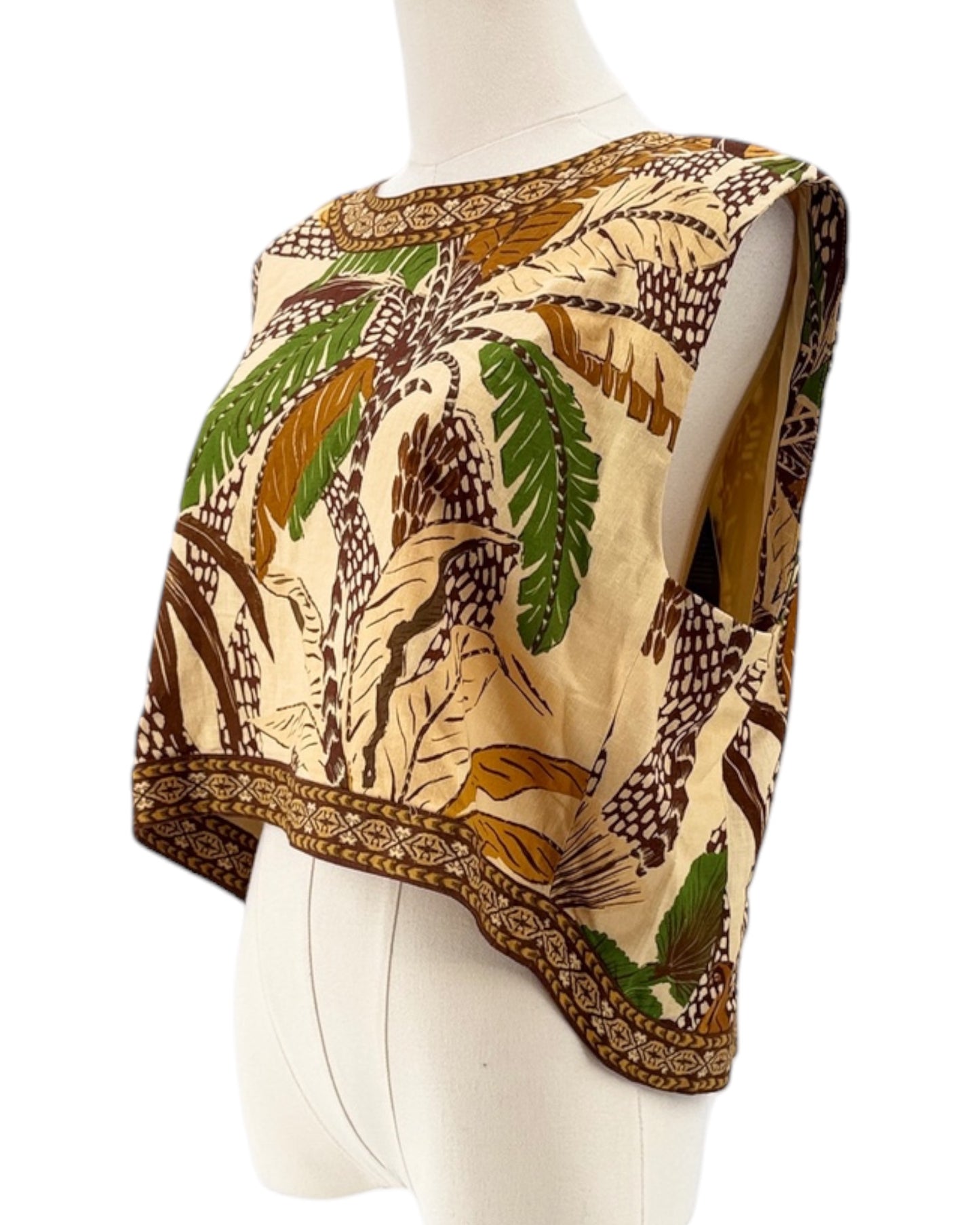 Mannequin wearing a patterned top with leaf design on a white background