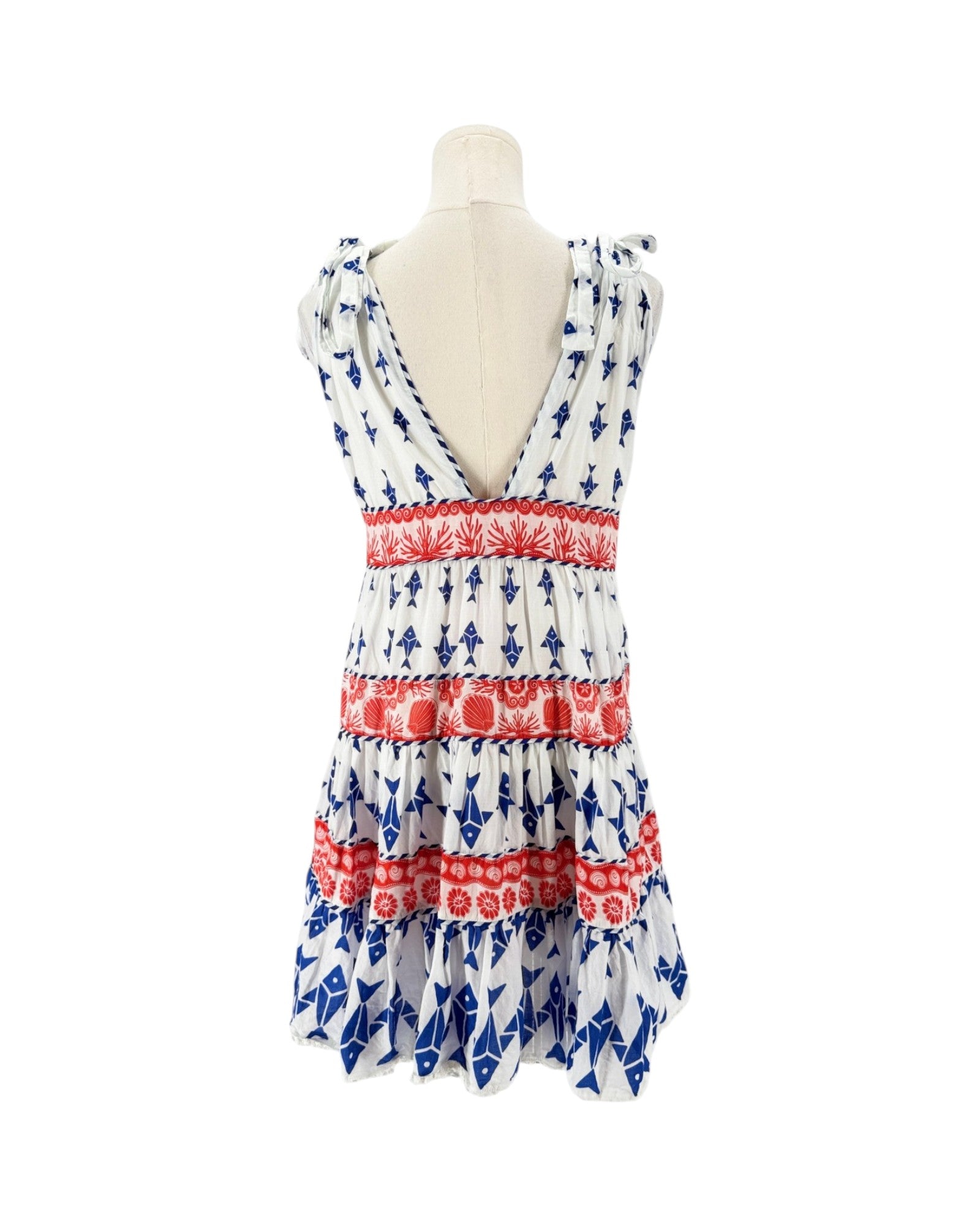 A sleeveless tiered dress displayed on a mannequin torso against a plain white background. The dress has a white base with blue anchor patterns and red horizontal bands with floral motifs.