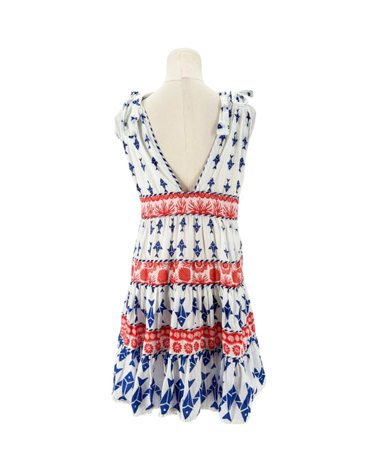 A sleeveless tiered dress displayed on a mannequin torso against a plain white background. The dress has a white base with blue anchor patterns and red horizontal bands with floral motifs.