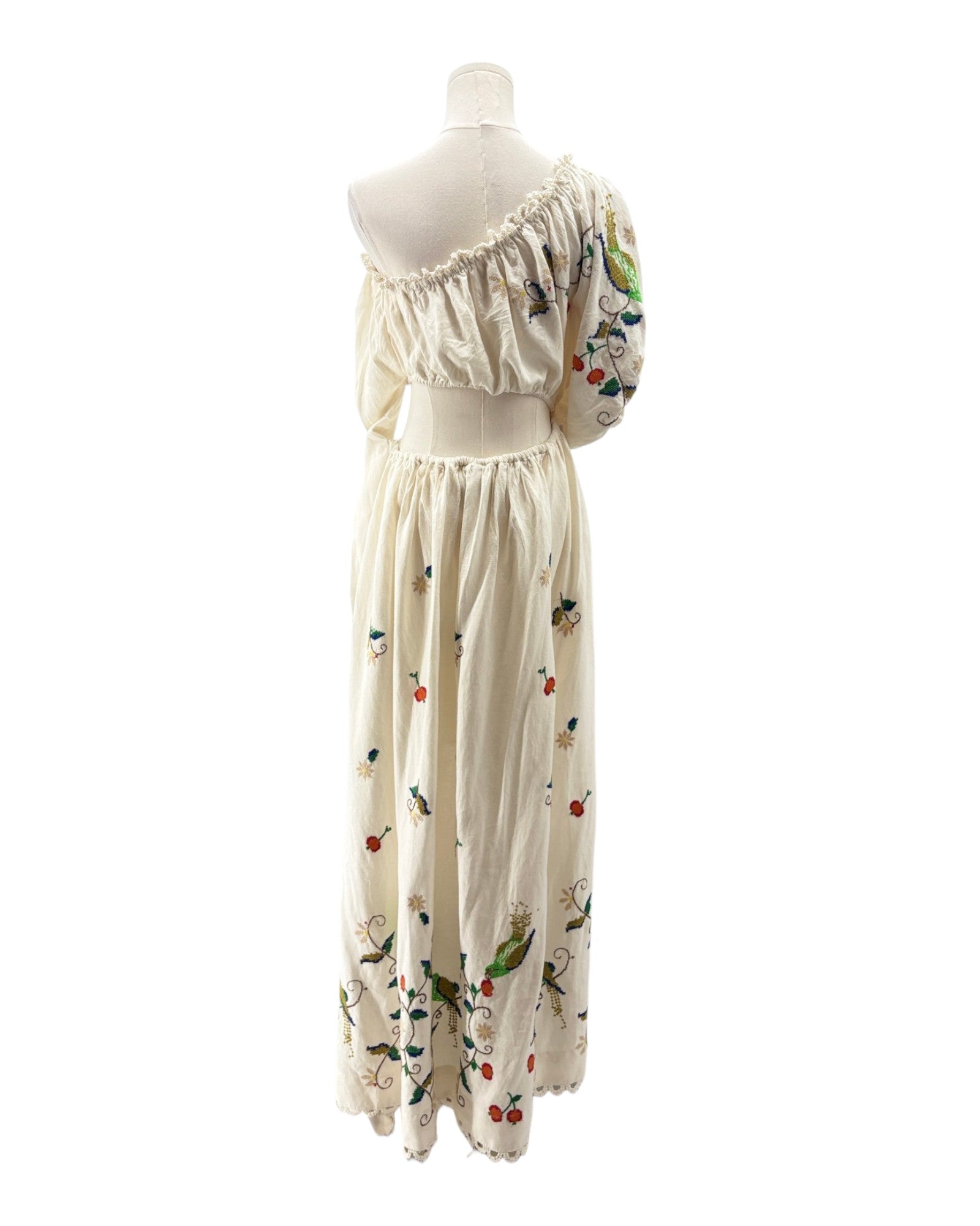 White dress with floral embroidery on a mannequin against a white background