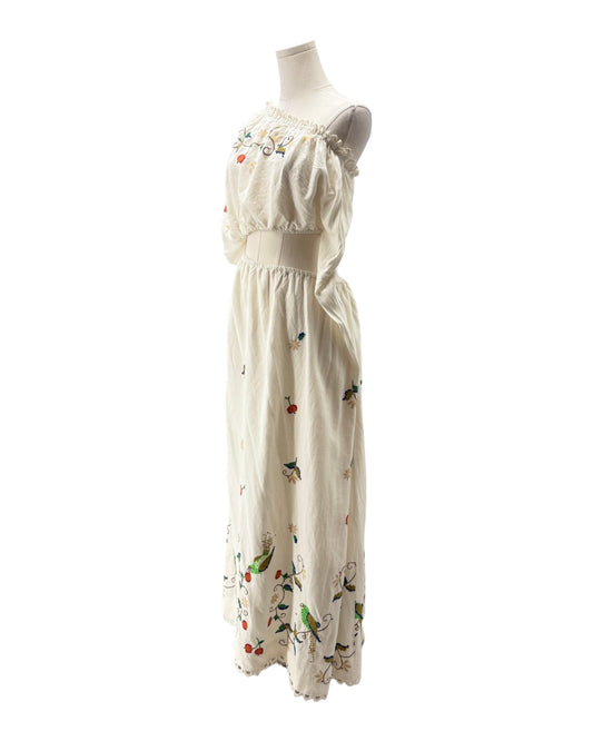 White dress with floral and bird patterns on a mannequin against a white background