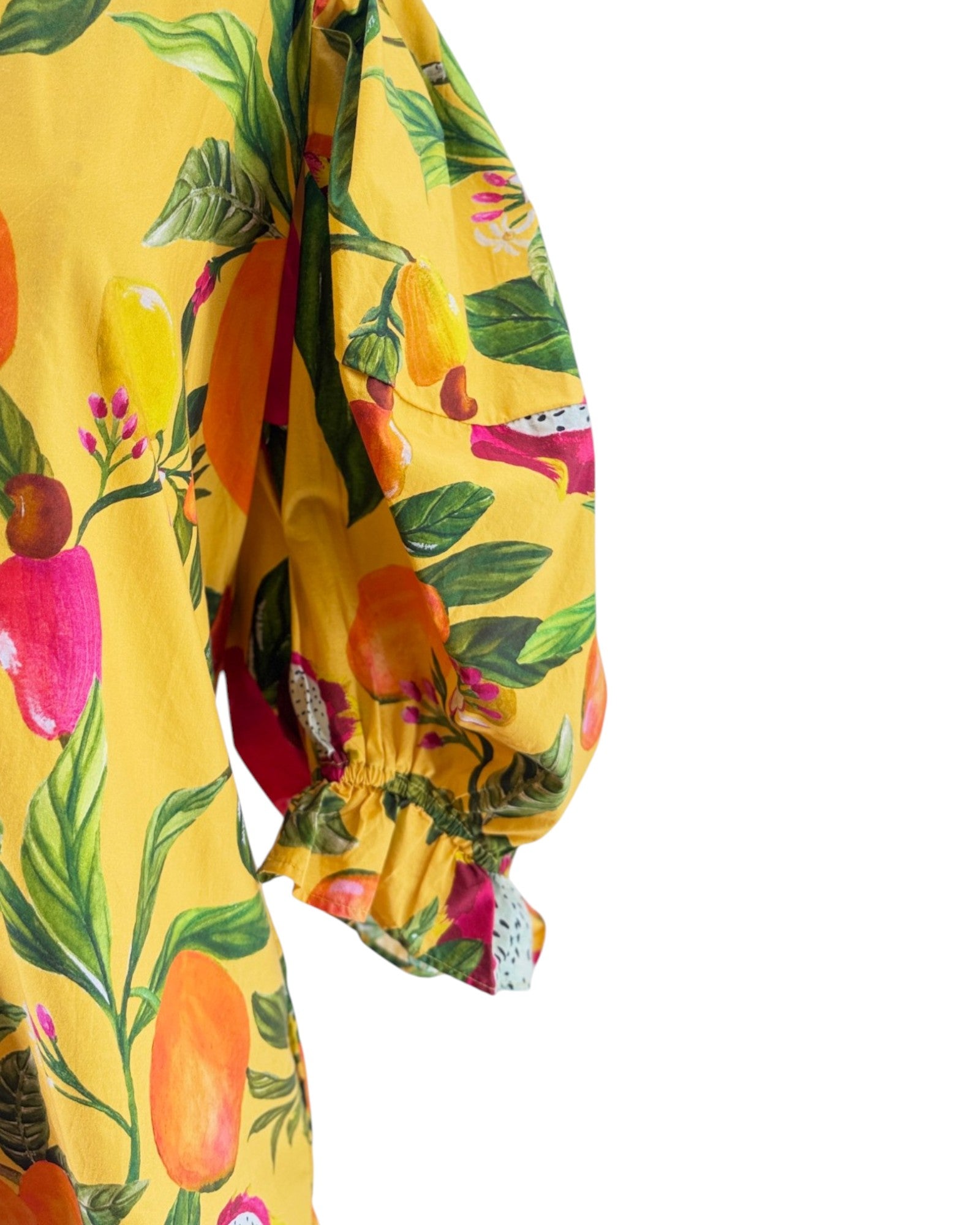 Yellow garment with tropical fruit and leaf pattern on a white background
