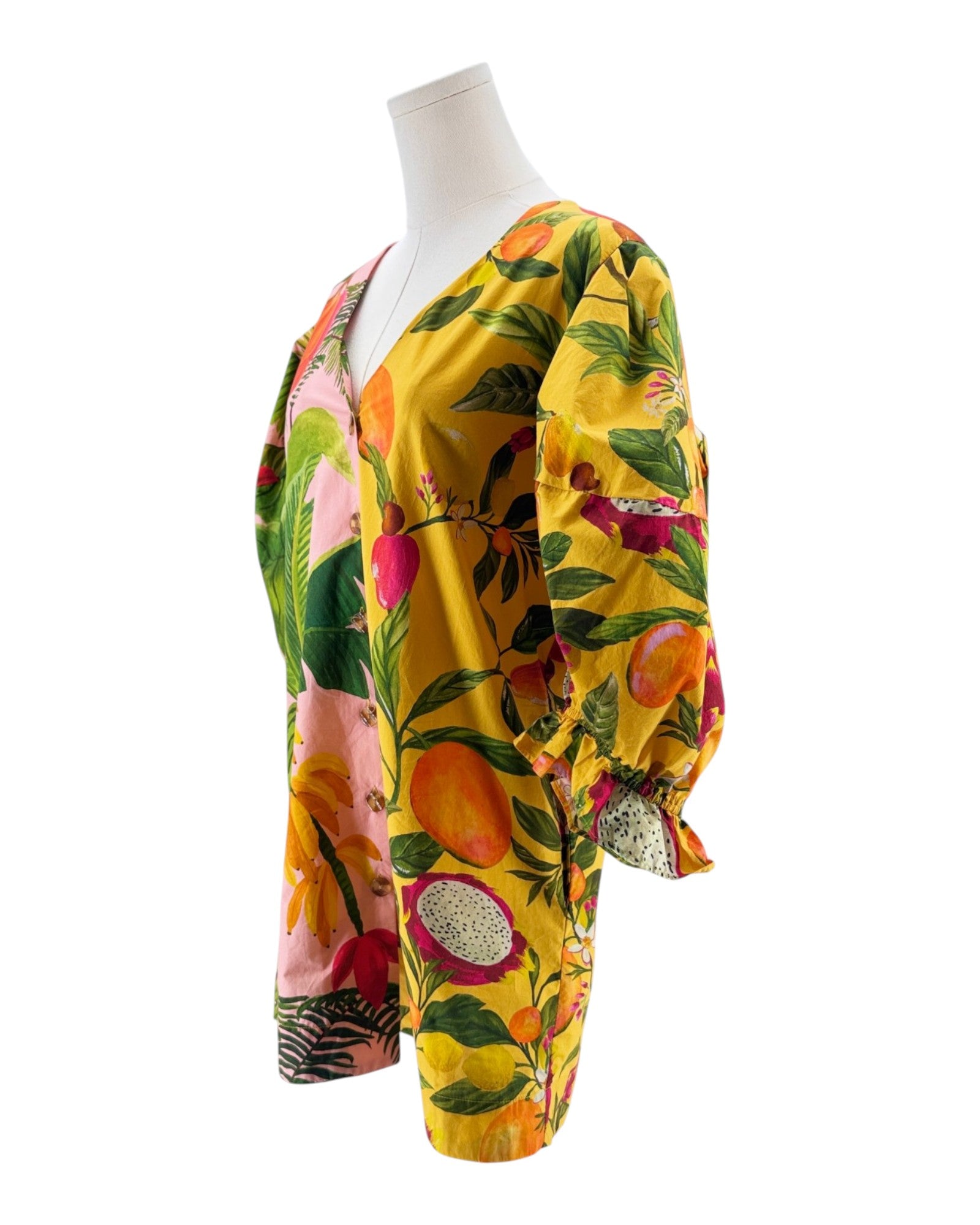 Colorful tropical print dress on a mannequin against a white background