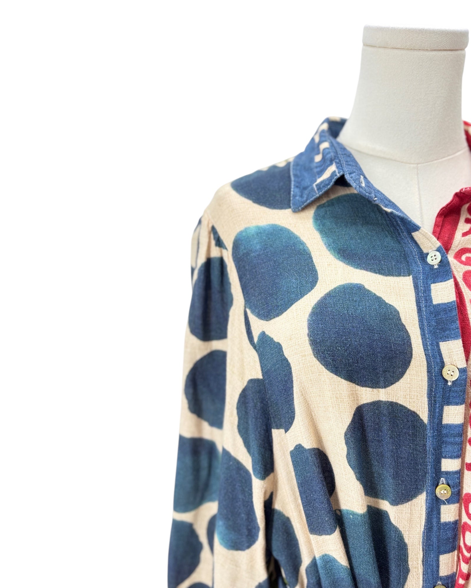 Mannequin wearing a blue and white patterned shirt with a plain background
