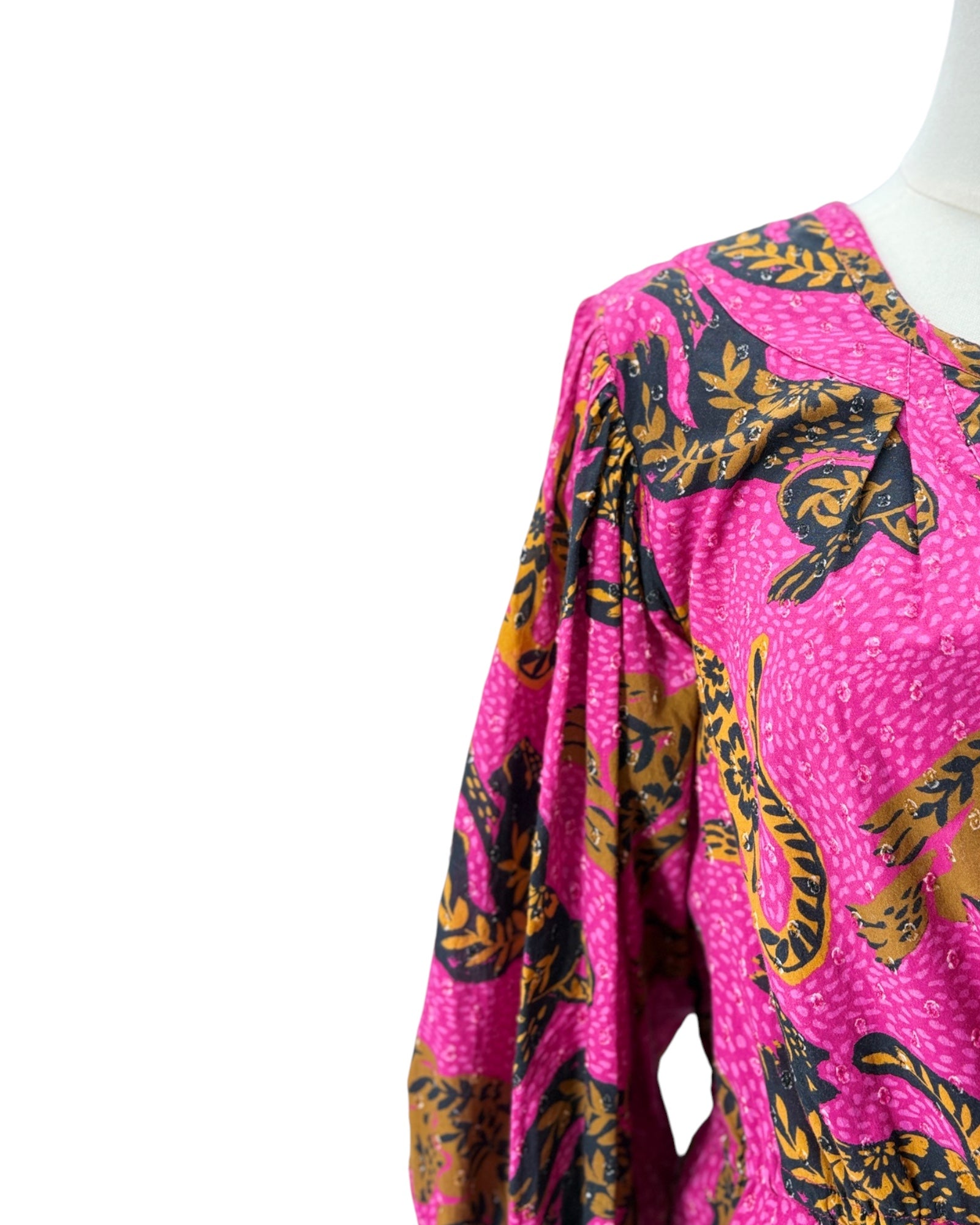 Pink garment with black and yellow floral pattern on a white background