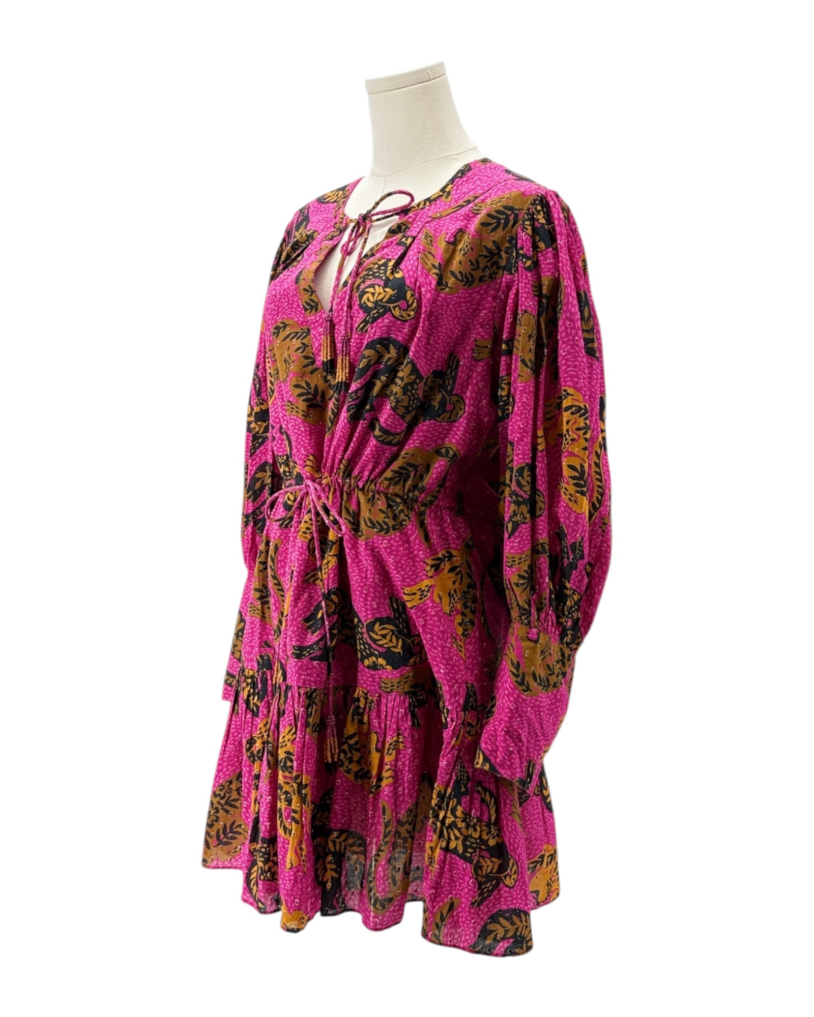 Pink dress with black and gold floral pattern on a mannequin against a white background