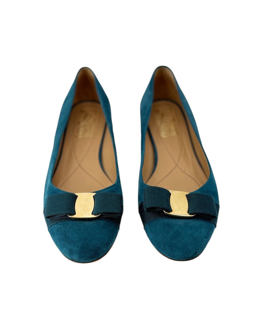 Pair of teal shoes with gold accents on a white background