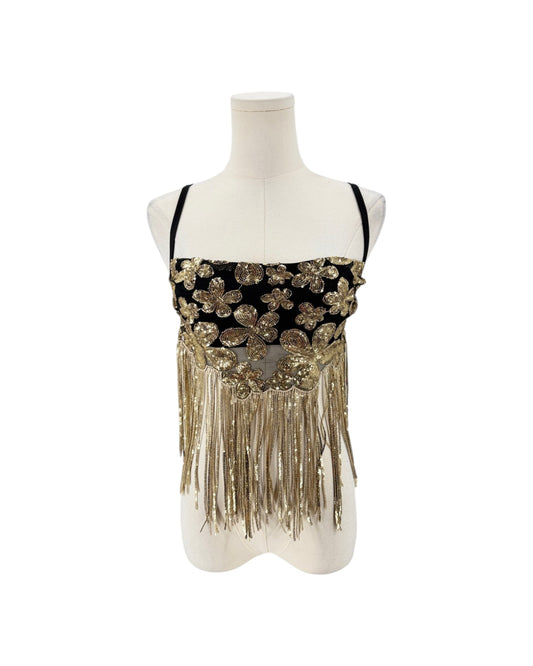 A black and gold embellished sleeveless top with floral sequin details and long fringe, displayed on a white mannequin torso against a white background.