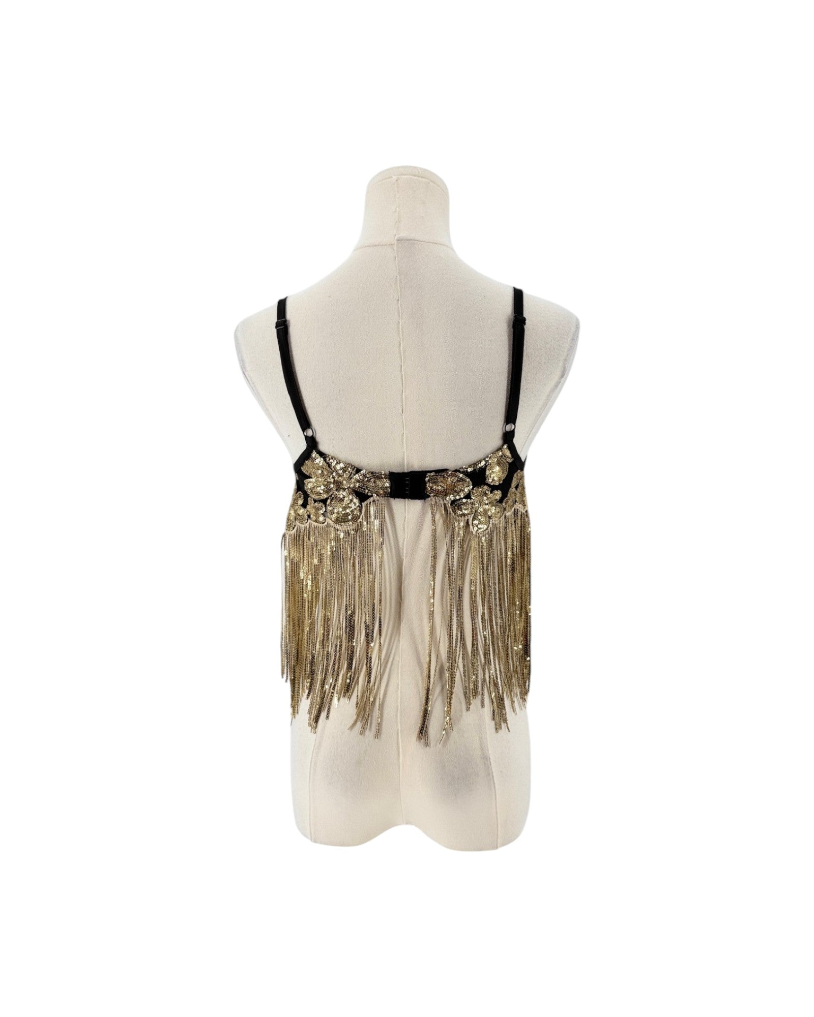 A black and gold sequined belly dance hip scarf with long fringe, displayed on a cream-colored mannequin torso against a white background.