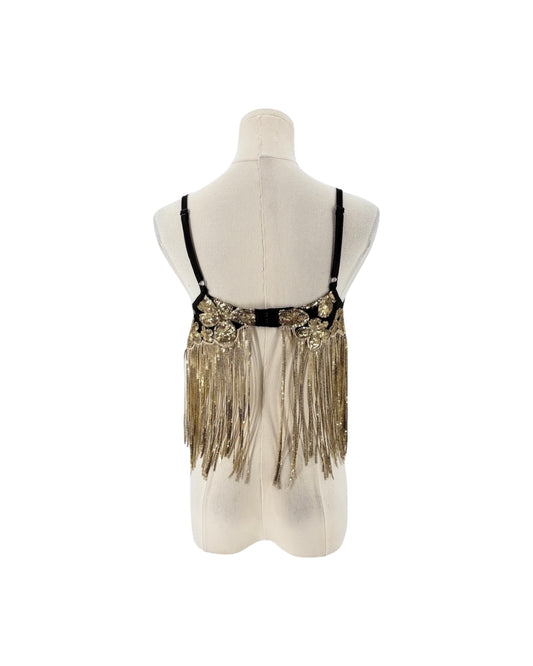 A black and gold sequined belly dance hip scarf with long fringe, displayed on a cream-colored mannequin torso against a white background.