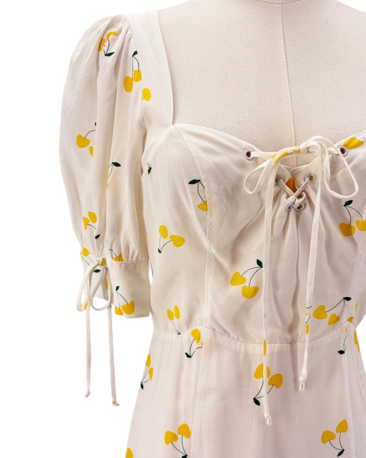 For love and lemons white dress with yellow floral pattern on a mannequin against a white background