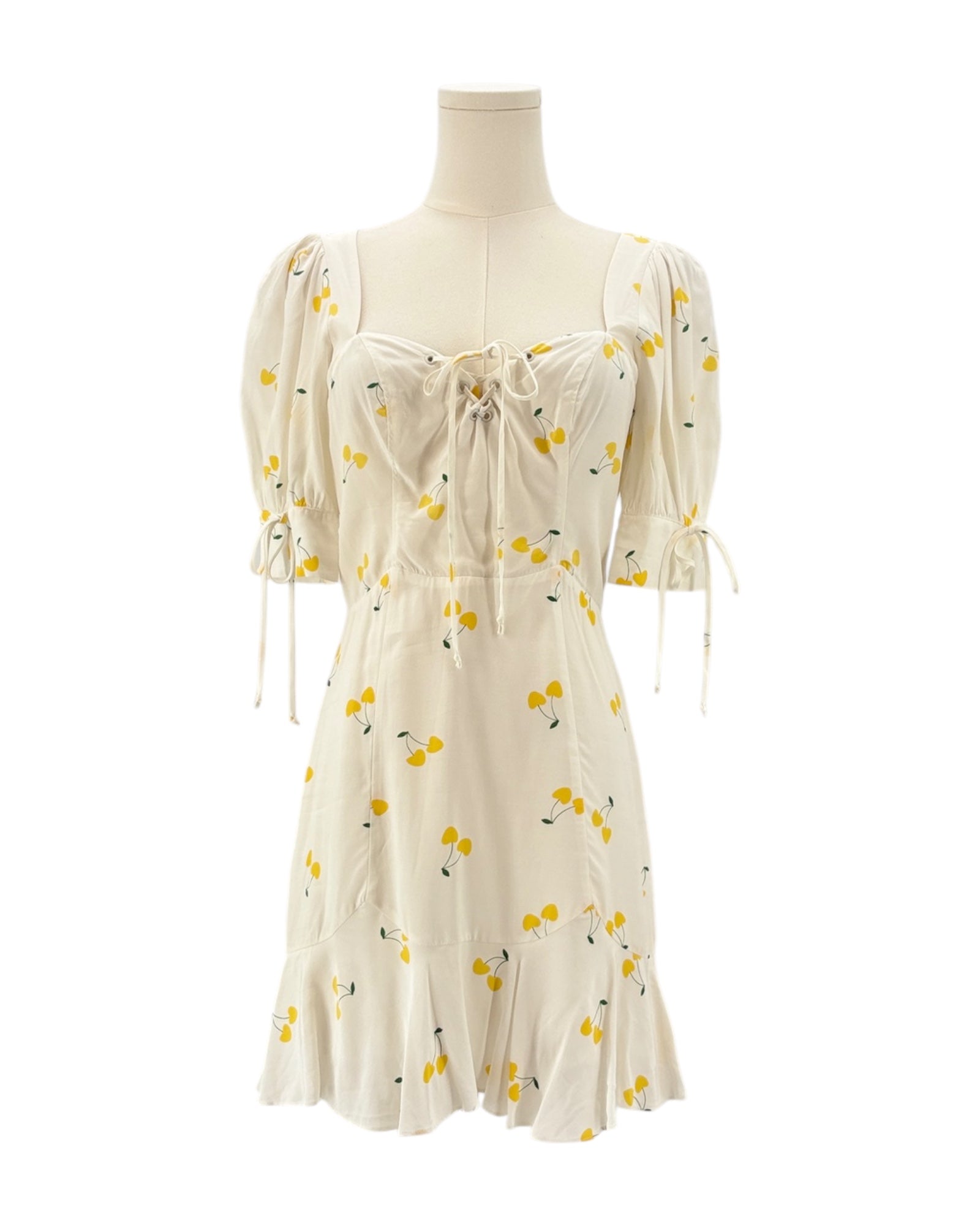 For love and lemons white dress with yellow floral pattern on a mannequin against a white background