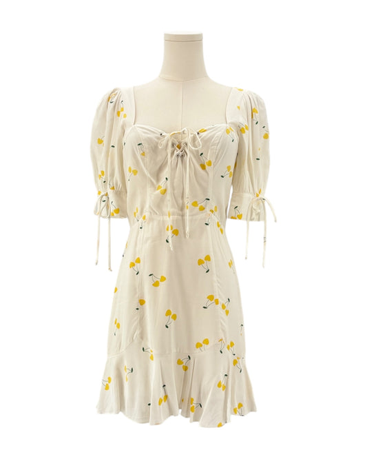 For love and lemons white dress with yellow floral pattern on a mannequin against a white background