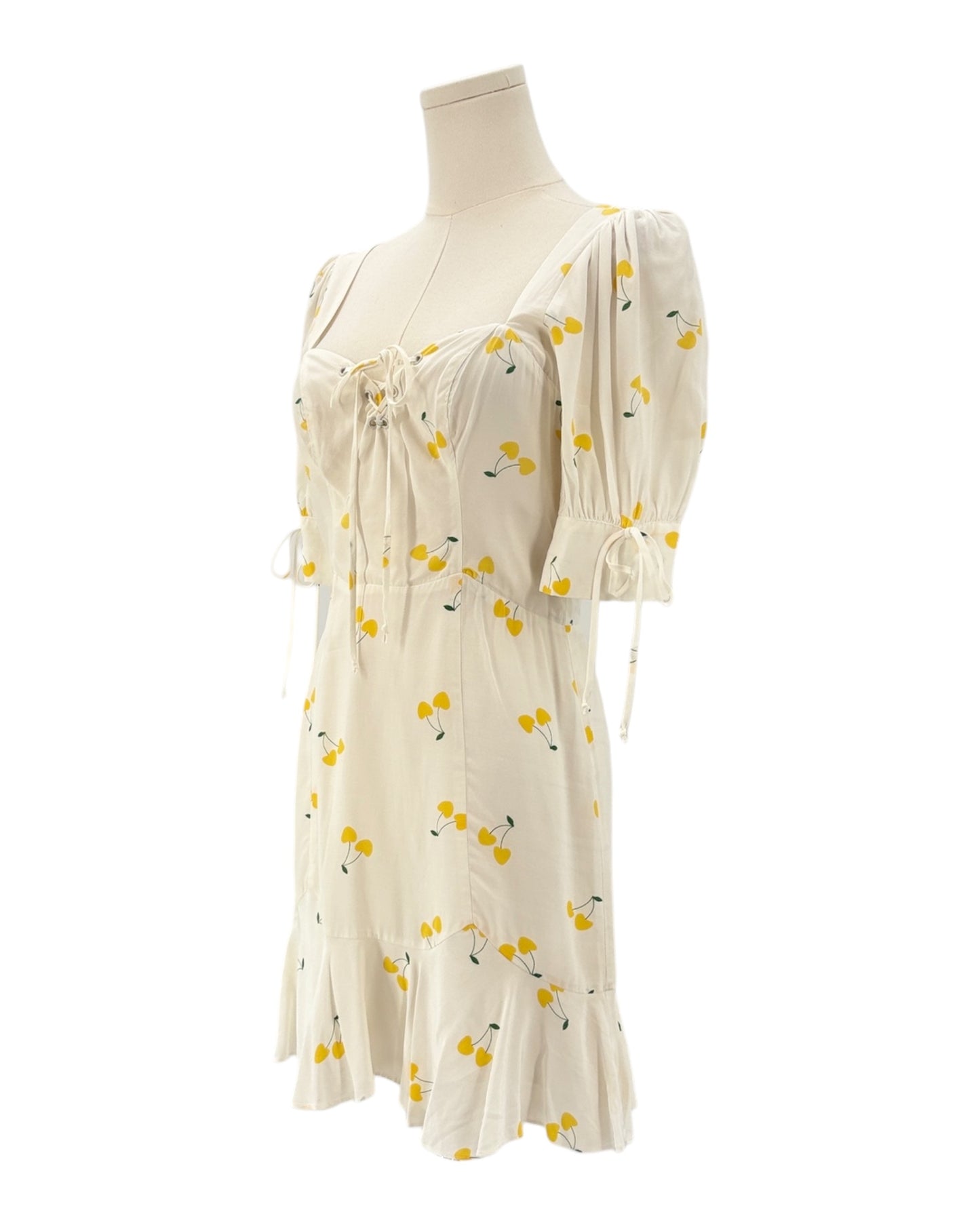 For love and lemons white dress with yellow floral pattern on a mannequin against a white background