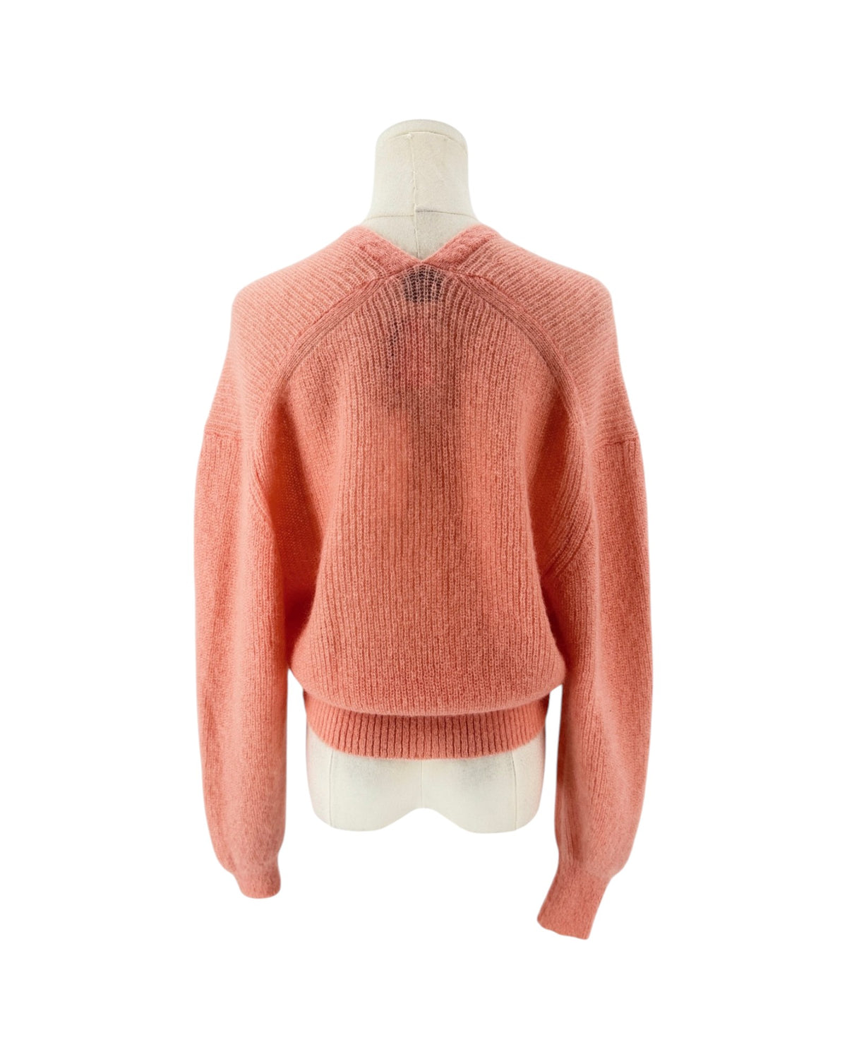 A coral pink knit cardigan sweater displayed on a cream-colored mannequin torso against a plain white background.