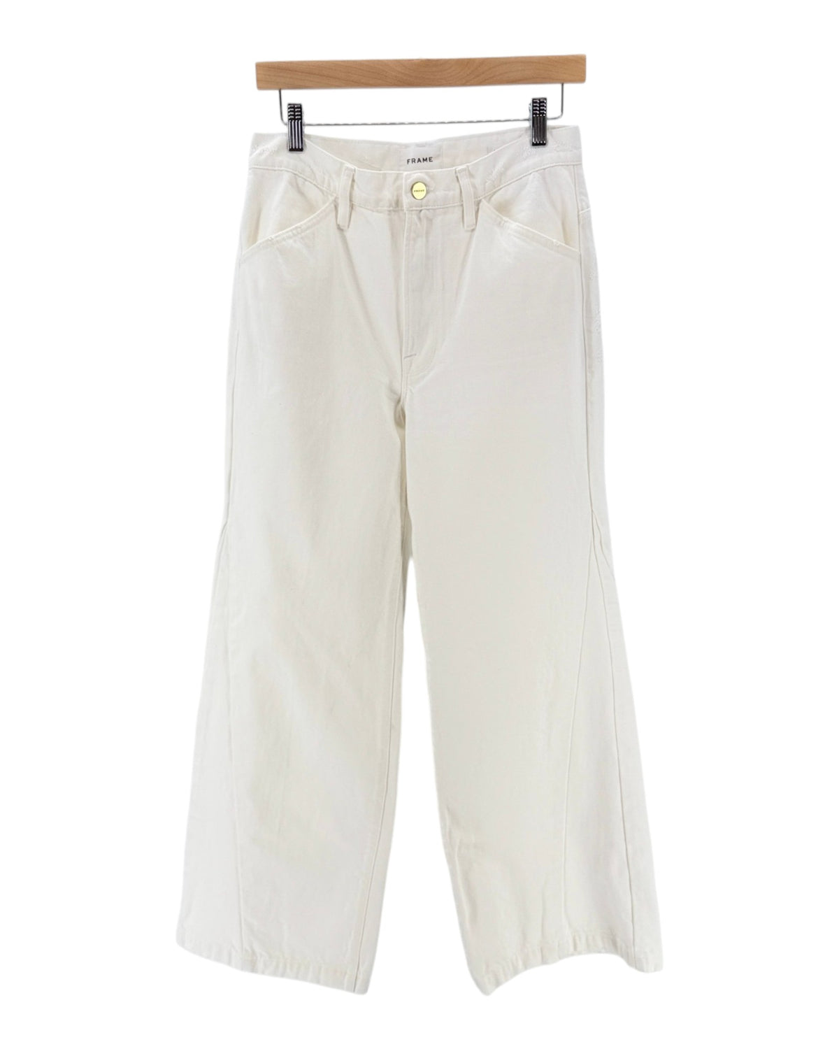 Off-white wide-leg cropped pants hanging from a wooden hanger against a plain white background.