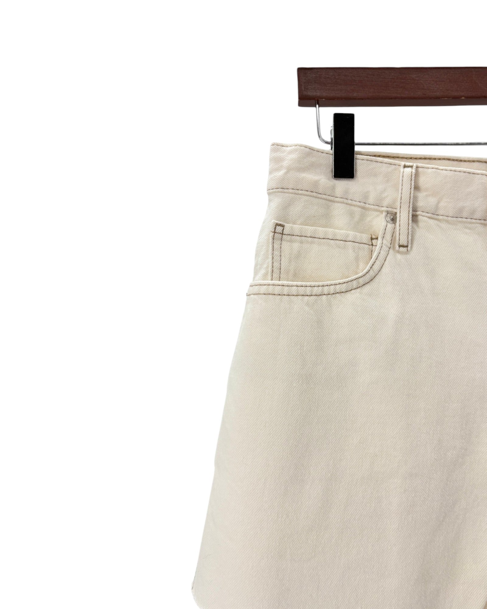 Beige pants on a hanger against a white background