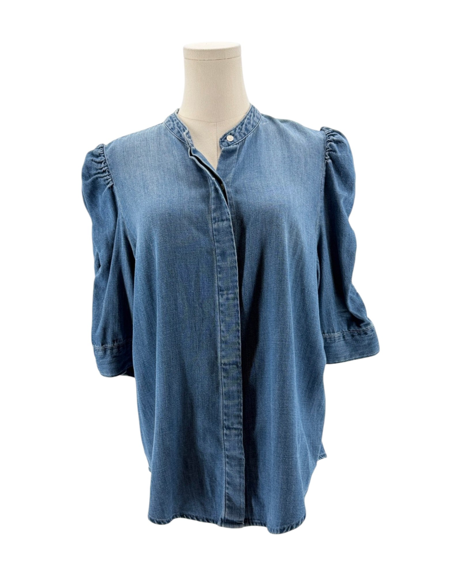 Blue denim shirt on a mannequin against a white background