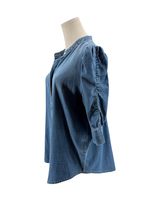 Blue denim shirt on a mannequin against a white background