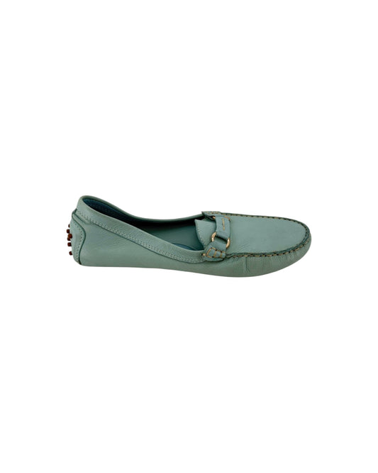 A light blue-green leather penny loafer with gold-tone hardware, shown from a top-down view on a white background.