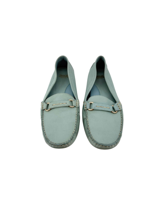 A pair of light blue-green leather penny loafers with gold-tone hardware, shown from a top-down view on a white background.